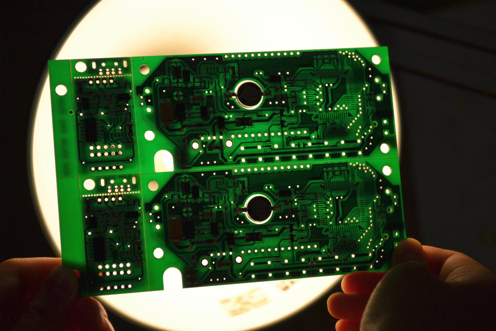 Green circuit board held up to light